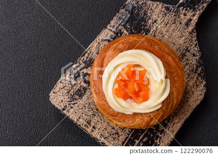 Sweet dessert danish covered with white cream and citrus, with cream filling Sweet dessert danish covered with white cream and citrus, with cream filling 122290076