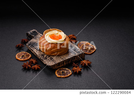 Sweet dessert danish covered with white cream and citrus, with cream filling Sweet dessert danish covered with white cream and citrus, with cream filling 122290084