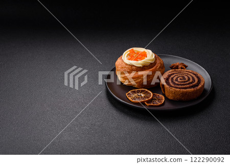 Sweet dessert danish covered with white cream and citrus, with cream filling 122290092