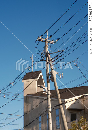 Electric pole and church in a residential area Electric pole and church in a residential area 122290381