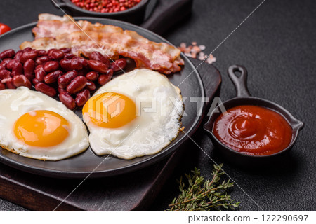 English breakfast with fried eggs, bacon, beans, tomatoes, spices and herbs 122290697