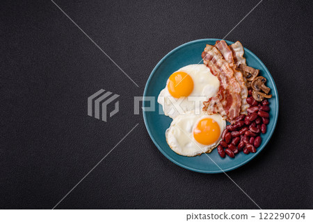 English breakfast with fried eggs, bacon, beans, tomatoes, spices and herbs English breakfast with fried eggs, bacon, beans, tomatoes, spices and herbs 122290704