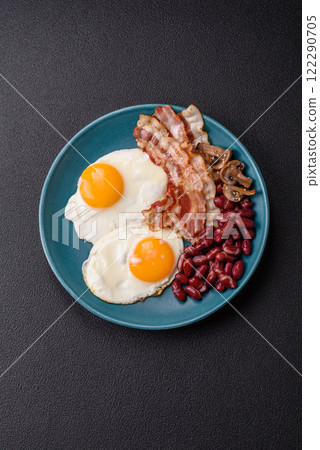 English breakfast with fried eggs, bacon, beans, tomatoes, spices and herbs 122290705