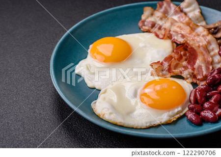 English breakfast with fried eggs, bacon, beans, tomatoes, spices and herbs 122290706