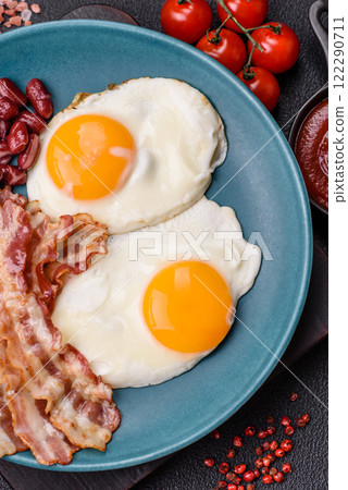 English breakfast with fried eggs, bacon, beans, tomatoes, spices and herbs 122290711