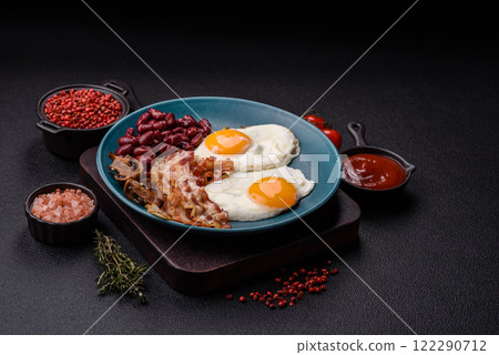 English breakfast with fried eggs, bacon, beans, tomatoes, spices and herbs English breakfast with fried eggs, bacon, beans, tomatoes, spices and herbs 122290712