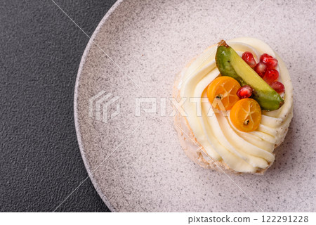 Piece of sweet meringue with citrus, kiwi and pomegranate seeds Piece of sweet meringue with citrus, kiwi and pomegranate seeds 122291228