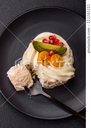 Piece of sweet meringue with citrus, kiwi and pomegranate seeds Piece of sweet meringue with citrus, kiwi and pomegranate seeds 122291251