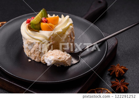 Piece of sweet meringue with citrus, kiwi and pomegranate seeds 122291252