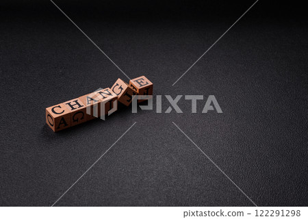 The inscription chance or change with wooden cubes on a dark concrete background 122291298
