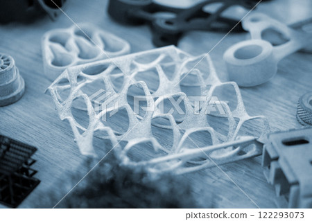 Various objects printed on 3D printer from molten plastic powder. Different models printed on 3D printer from melted grey polyamide powder. Additive 3D printing Multi Jet Fusion MJF technology Various objects printed on 3D printer from molten plastic powder. Different models printed on 3D printer from melted grey polyamide powder. Additive 3D printing Multi Jet Fusion MJF technology 122293073