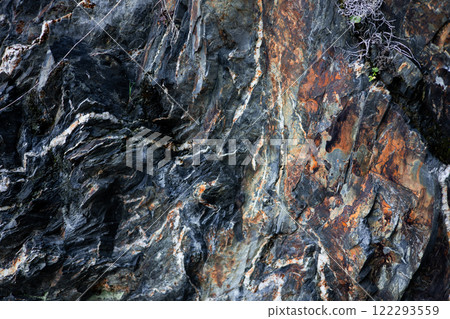 Close up of textured multicolored rock formation with striations Close up of textured multicolored rock formation with striations 122293559