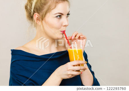 Happy woman holding fresh orange juice 122293760