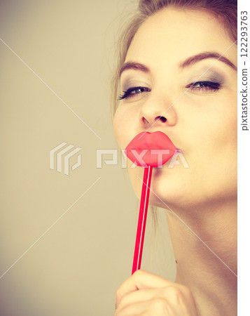 Happy woman holding fake lips on stick Happy woman holding fake lips on stick 122293763