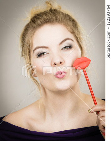 Happy woman holding lips on stick Happy woman holding lips on stick 122293764
