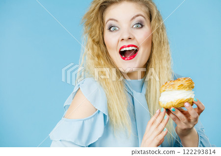 Funny woman holds cream puff cake Funny woman holds cream puff cake 122293814