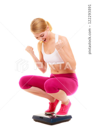 Happy successful woman weighing scale. Dieting. 122293891