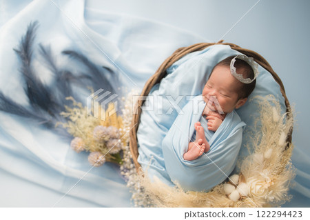 新生兒照片_新生嬰兒裹在襁褓中，微笑著安詳地睡著 122294423