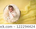 Newborn photo_A newborn baby sleeping peacefully with a happy smile wrapped in a swaddling cloth 122294424
