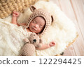 Newborn photo_A newborn baby sleeping peacefully with a happy smile wrapped in a swaddling cloth 122294425
