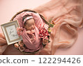 Newborn photo_A newborn baby sleeping peacefully with a happy smile wrapped in a swaddling cloth 122294426