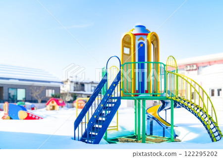 Snow-covered playground equipment at a nursery school Snow-covered playground equipment at a nursery school 122295202