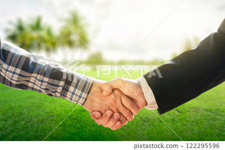 Business concept.Business handshake land purchase. Empty dry cracked swamp reclamation soil in real estate sale or property investment concept. Agriculture land plot for sales. 122295596