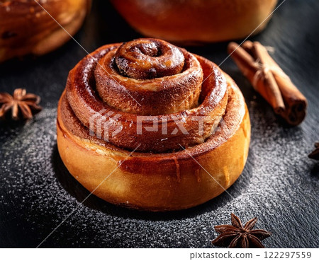 Swedish cinnamon buns or rolls. Freshly baked buns on a black stone table Swedish cinnamon buns or rolls. Freshly baked buns on a black stone table 122297559