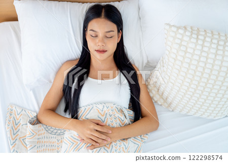 Top view beautiful Asian woman lie and sleep on bed with white pillow and express relax happiness. 122298574