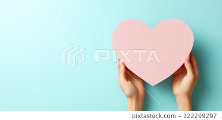 Pink heart paper with hands on light background Pink heart paper with hands on light background 122299297