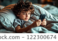 A boy with a phone in bed 122300674