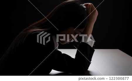 黑暗中抱著膝蓋的憂鬱婦女的剪影 3 122300877