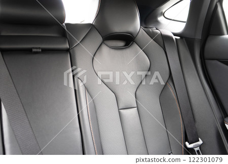 Back passenger black seats in modern luxury car. Black perforated leather with white stitching. Car details. Leather comfortable seats. Car interior details Back passenger black seats in modern luxury car. Black perforated leather with white stitching. Car details. Leather comfortable seats. Car interior details 122301079