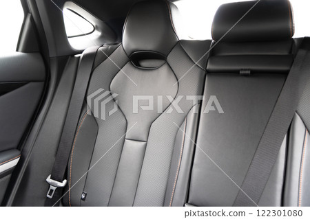 Back passenger black seats in modern luxury car. Black perforated leather with white stitching. Car details. Leather comfortable seats. Car interior details Back passenger black seats in modern luxury car. Black perforated leather with white stitching. Car details. Leather comfortable seats. Car interior details 122301080