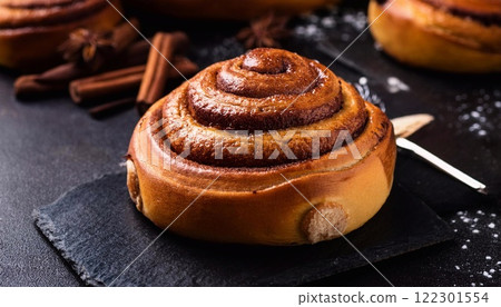 Swedish cinnamon buns or rolls. Freshly baked buns on a black stone table 122301554