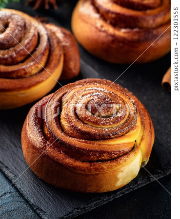 Swedish cinnamon buns or rolls. Freshly baked buns on a black stone table 122301558