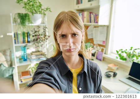 Close-up selfie portrait of teenage confused female looking at web camera Close-up selfie portrait of teenage confused female looking at web camera 122301613