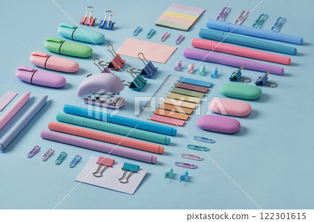 Stationery background with pastel-colored office supplies neatly arranged on a light blue background. Selective focus. Stationery background with pastel-colored office supplies neatly arranged on a light blue background. Selective focus. 122301615