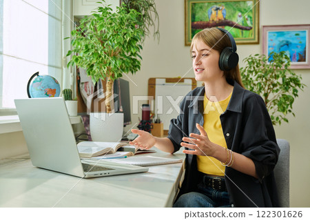Girl teenage student in headphones having video chat online on computer 122301626