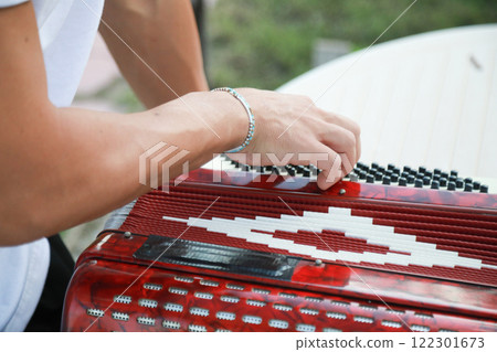 Man Testing All The Buttons Of His Accordion  122301673