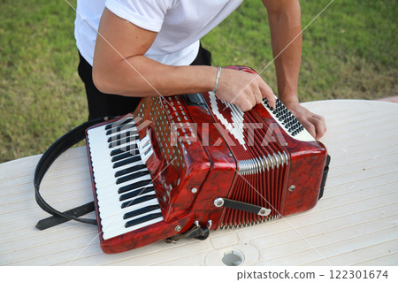 Man Using Tool To Fix And Tune Accordion  122301674