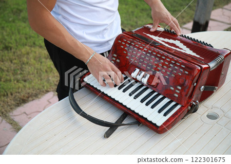 Man Testing All The Buttons Of His Accordion Man Testing All The Buttons Of His Accordion 122301675