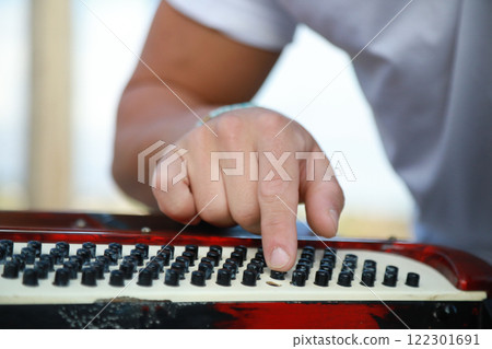 Man Testing All The Buttons Of His Accordion Man Testing All The Buttons Of His Accordion 122301691
