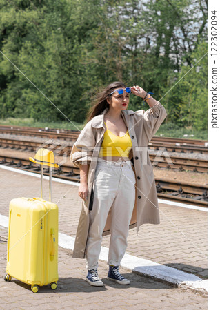The light of the future: her eyes reflect the hope for a bright future filled with moments of joy. World in a suitcase: the image of a young woman with a suitcase symbolizes endless possibilities in a 122302094