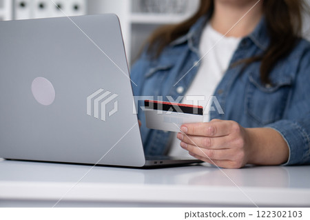 The Digital Shopping Experience A woman engaging in an online payment process using her laptop, blending technology with her lifestyle, reflecting her hobbies and retail spending habits 122302103