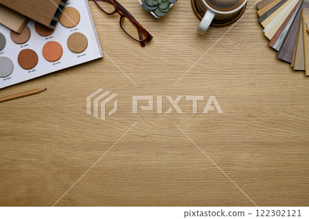 Creative design workspace with color samples, coffee cup and glasses on a wooden surface 122302121
