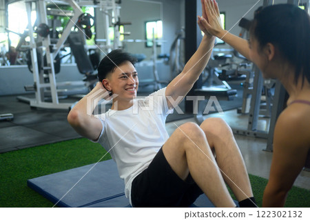 Happy athletic couple working out together in the gym. 122302132