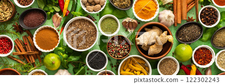 A beautiful collection of colorful spices and herbs, showcasing their natural aromas and vibrant hues on a gentle green background, banner 122302243