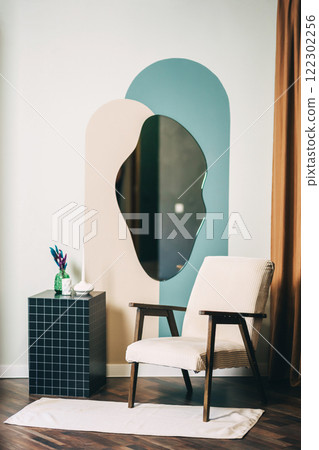 wooden chair with light fabric and pedestal against wall with mirror. photo zone with chair 122302256