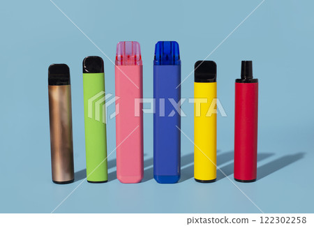 Set of colorful disposable electronic cigarettes on a blue background. The concept of modern smoking 122302258